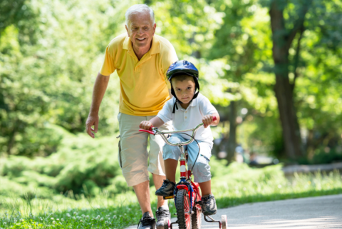 Grandpa helping kid ride bike